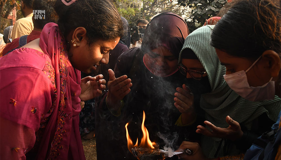 টিয়ার গ্যাসে চোখের জ্বালাপোড়া কমাতে কাগজ জ্বালিয়ে চোখে ধোঁয়া দিচ্ছেন কয়েকজন। ছবি : হারুন-অর-রশীদ 